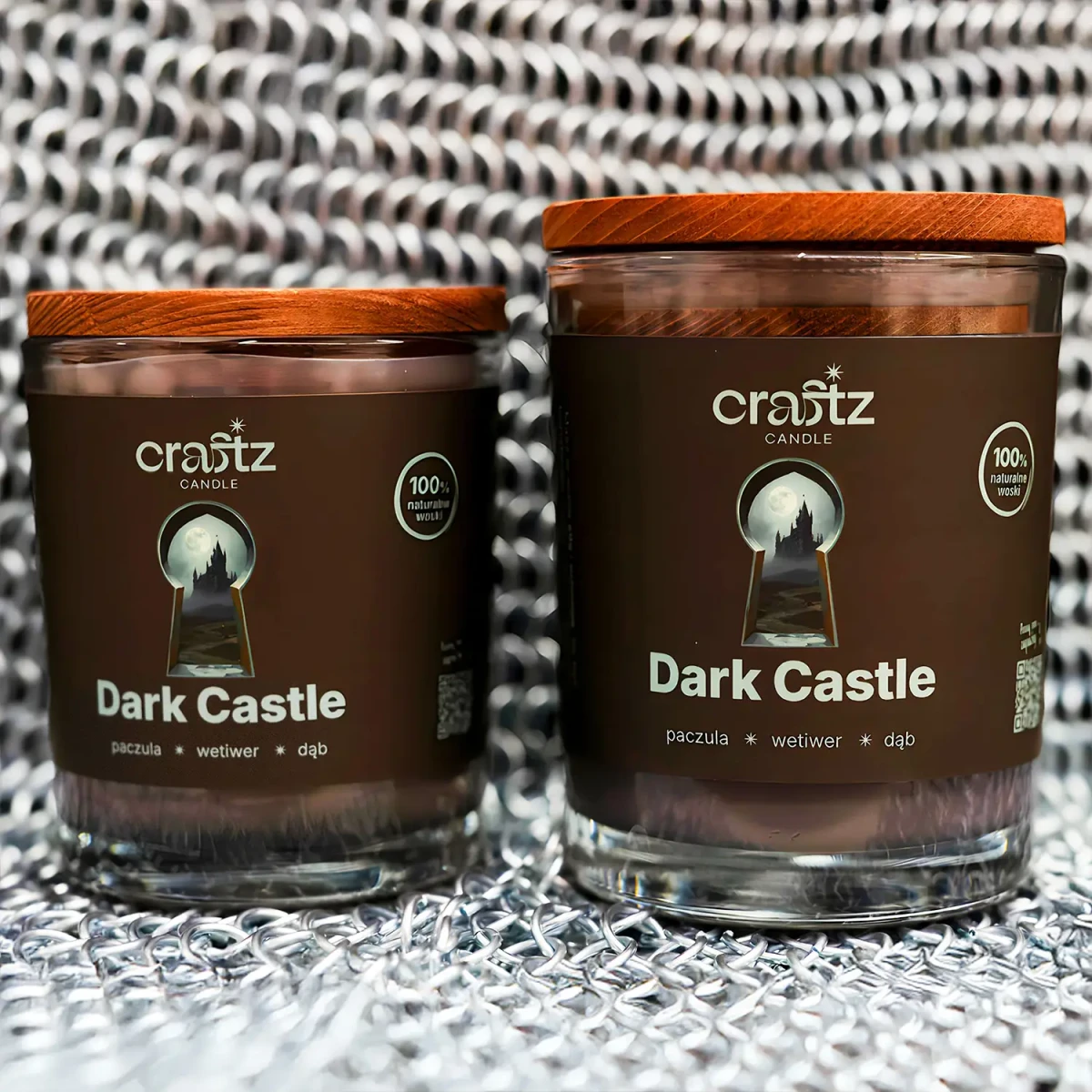 Dwie świece sojowe Dark Castle Craftz Candle na tle metalowej kolczugi