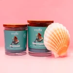 Dwie świece sojowe Mermaid Craftz Candle z muszlą w różowo-morskiej aranżacji