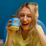 Świeca sojowa Vibrant Chaos Craftz Candle w niebiesko-żółtej aranżacji z kobietą
