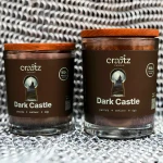 Dwie świece sojowe Dark Castle Craftz Candle na tle metalowej kolczugi