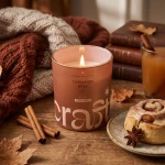 Świeca zapachowa Cinnamon Roll Craftz Candle w jesiennej aranżacji z cynamonem i bułeczką cynamonową